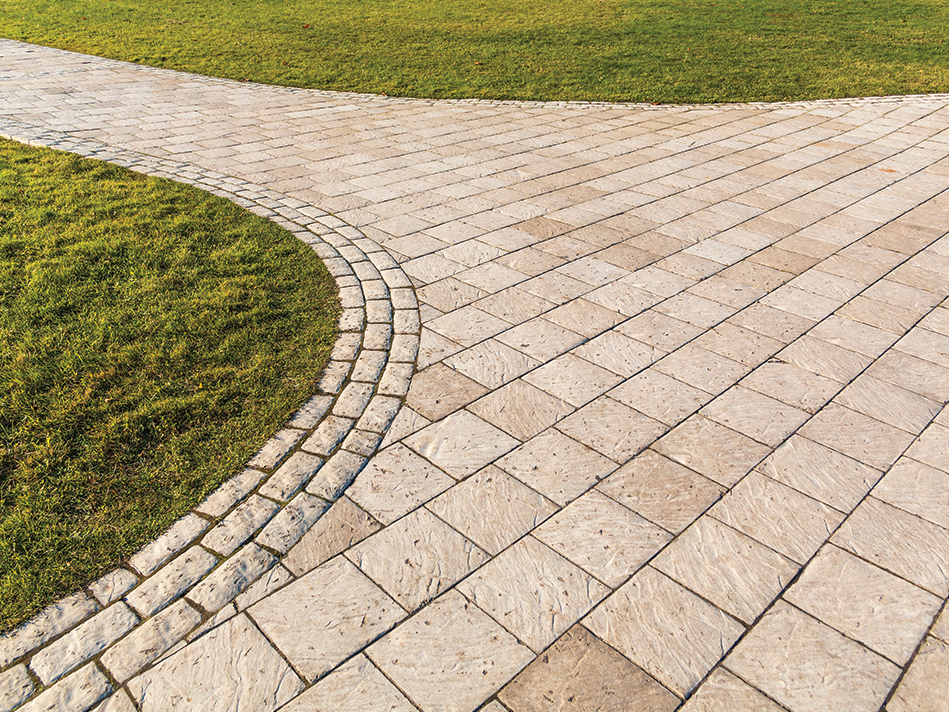 Tan pavers form a walkway in the middle of a green lawn