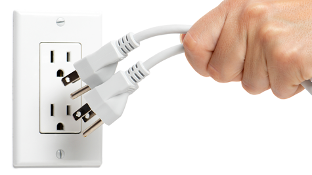 A white person's hand unplugs two white cords from a white outlet