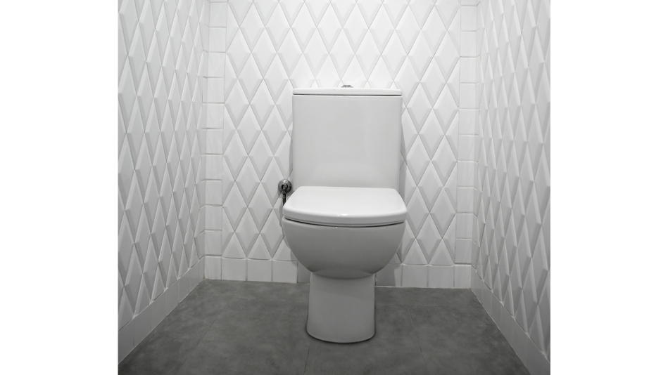 White diamond subway tile adorns the walls behind and beside a white toilet