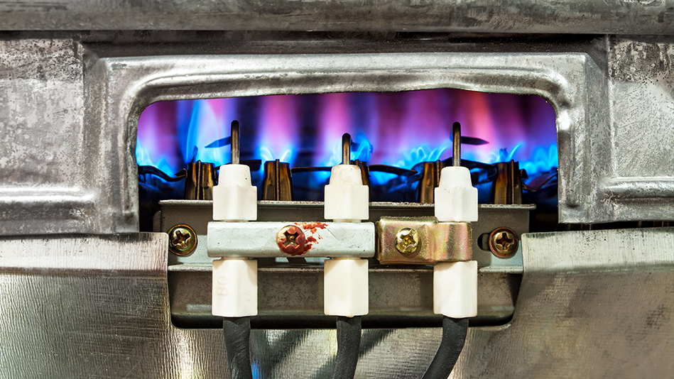 Blue and purple flames heat beneath a gas water heater