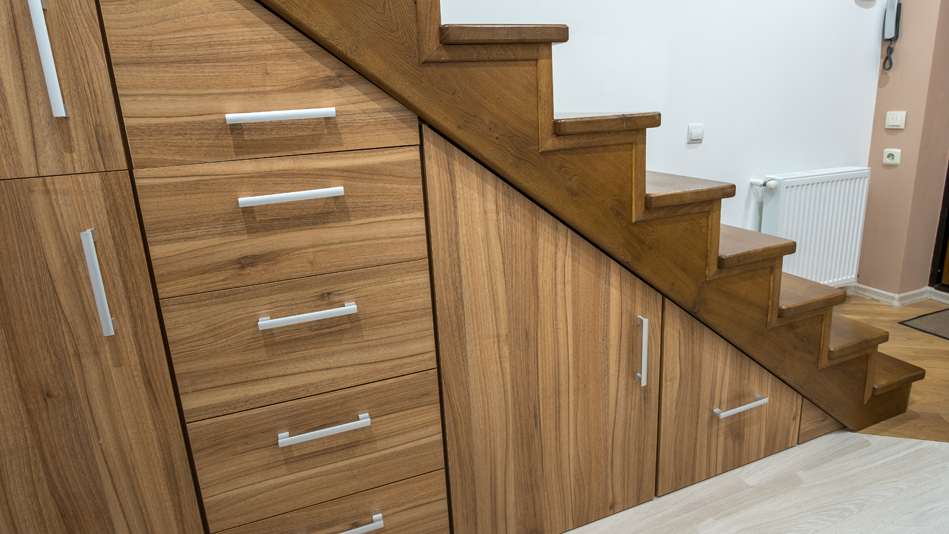 A side view of closed mahogany storage stairs with silver modern door pulls