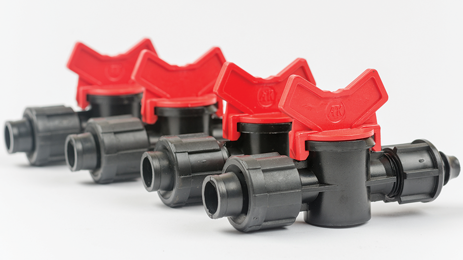4 red and black drip irrigation valves in an angled row
