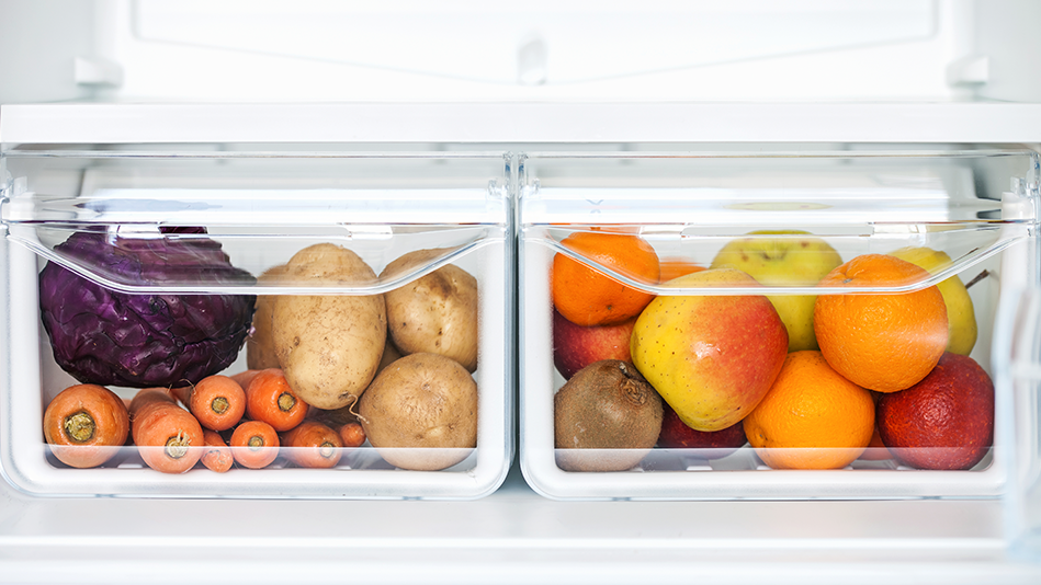2 transparent fridge crisper drawers underneath an empty fridge shelf; the left drawer contains 1 red cabbage, 8 carrots, and 4-5 light brown potatoes, and the right drawer contains an assortment of apples, oranges, clementines, and a kiwi   