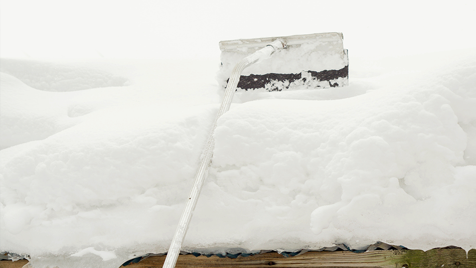 A roof rake reaches high into deep snow on a pitched roof