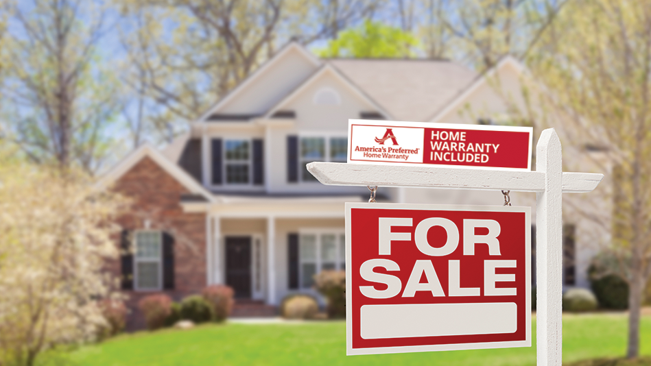 A for Sale sign with an America's Preferred Home Warranty rider sits in the front yard of a large brick home.