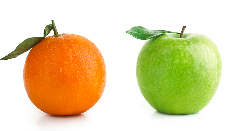 An orange sits next to a green apple on a white background
