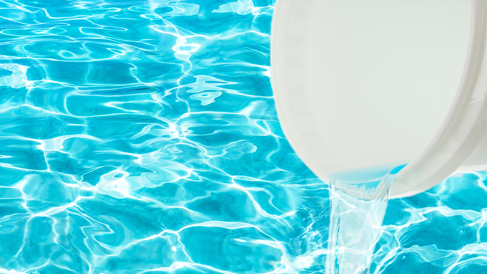 Open your pool: A large white bucket pours shock mixed with water into a pool