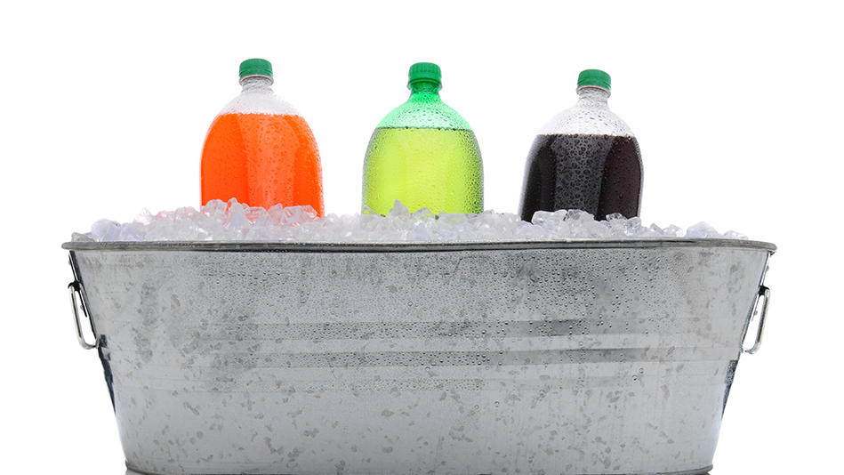 3 2-liters of pop (Left to right: orange, lime green, and dark brown) sit in a metal bucket loaded with ice