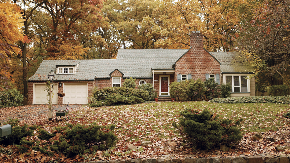 Brick home surrounded by fall colors and fallen leaves