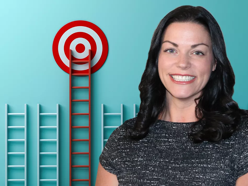 Renee Kozak in front of a series of ladders with a tall one in the middle just under a bullseye