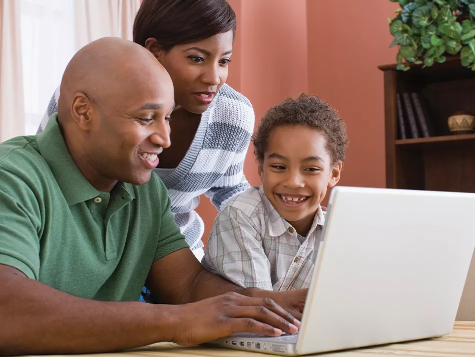 Black family uses a laptop computer together