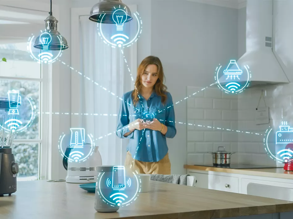 White woman looks at smartphone in kitchen with 7 large, blue, hologram device icons coming out of it