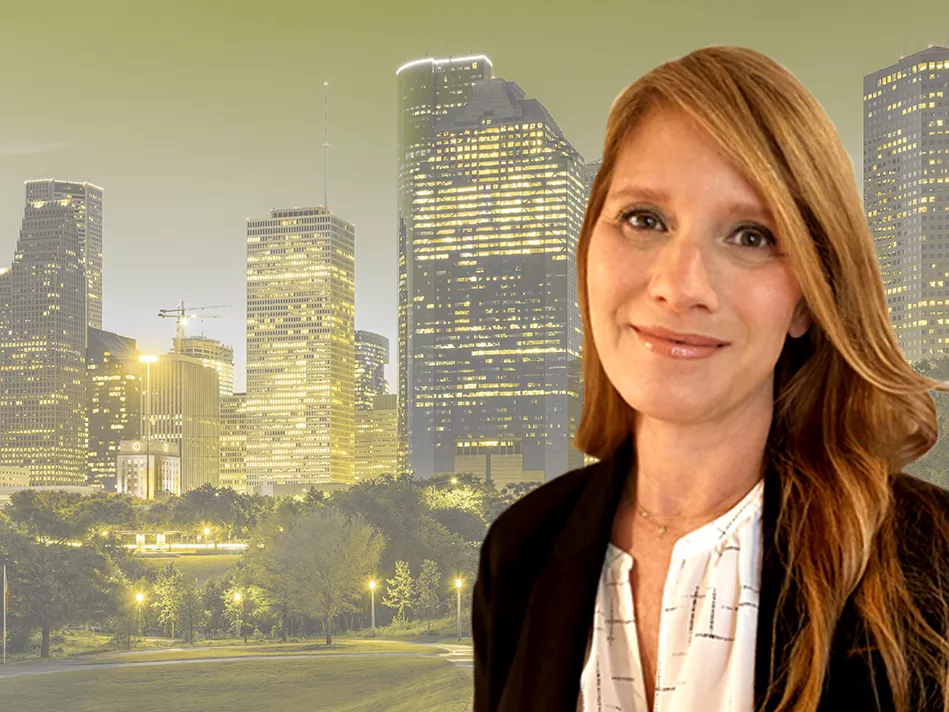 White female smiles in business professional attire, with a Houston background