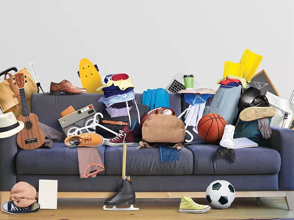 Household items are scattered across a long gray-blue couch