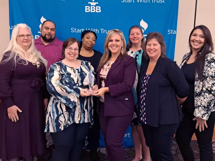 Eight employees from America's Preferred Home Warranty accept the Better Business Bureau Torch Award for Ethics